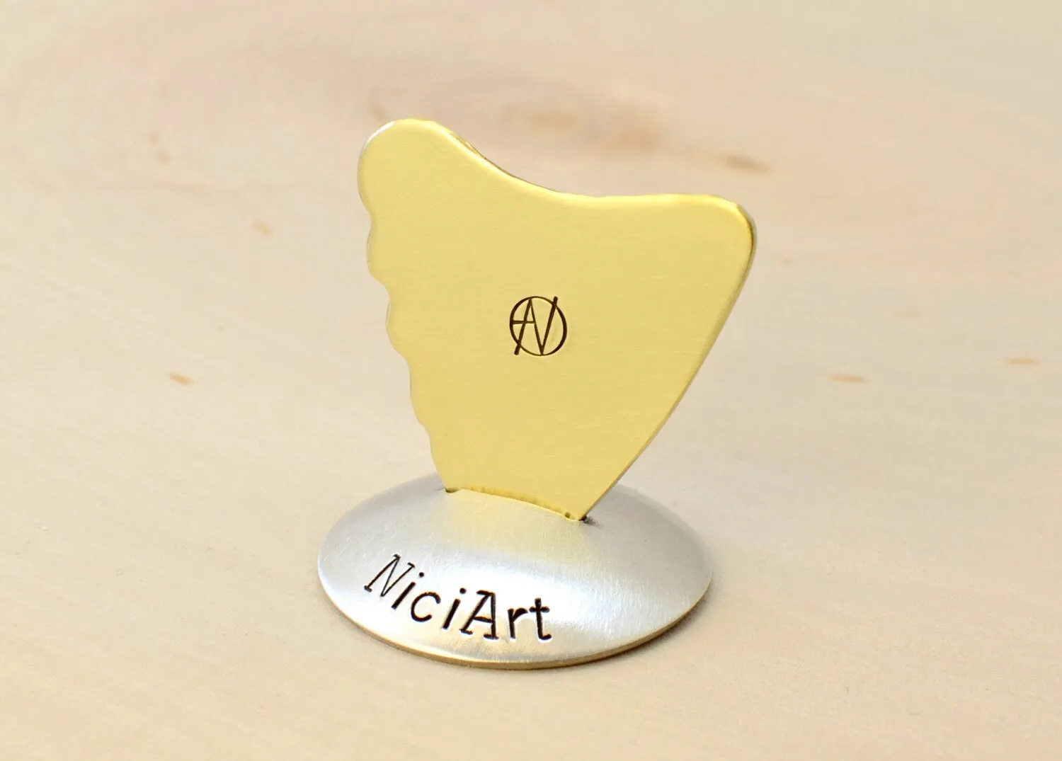 Shark Fin Brass Guitar Pick with a simple guitar theme
